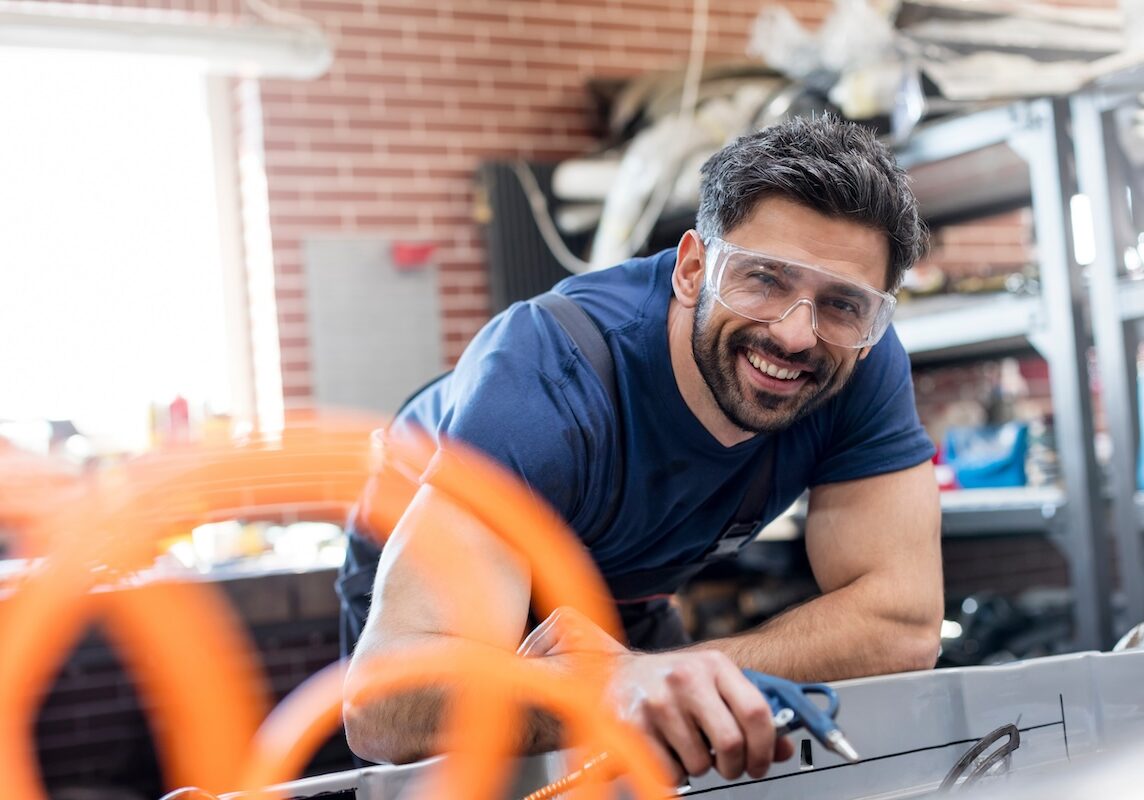 Portrait smiling mechanic working in auto repair shop